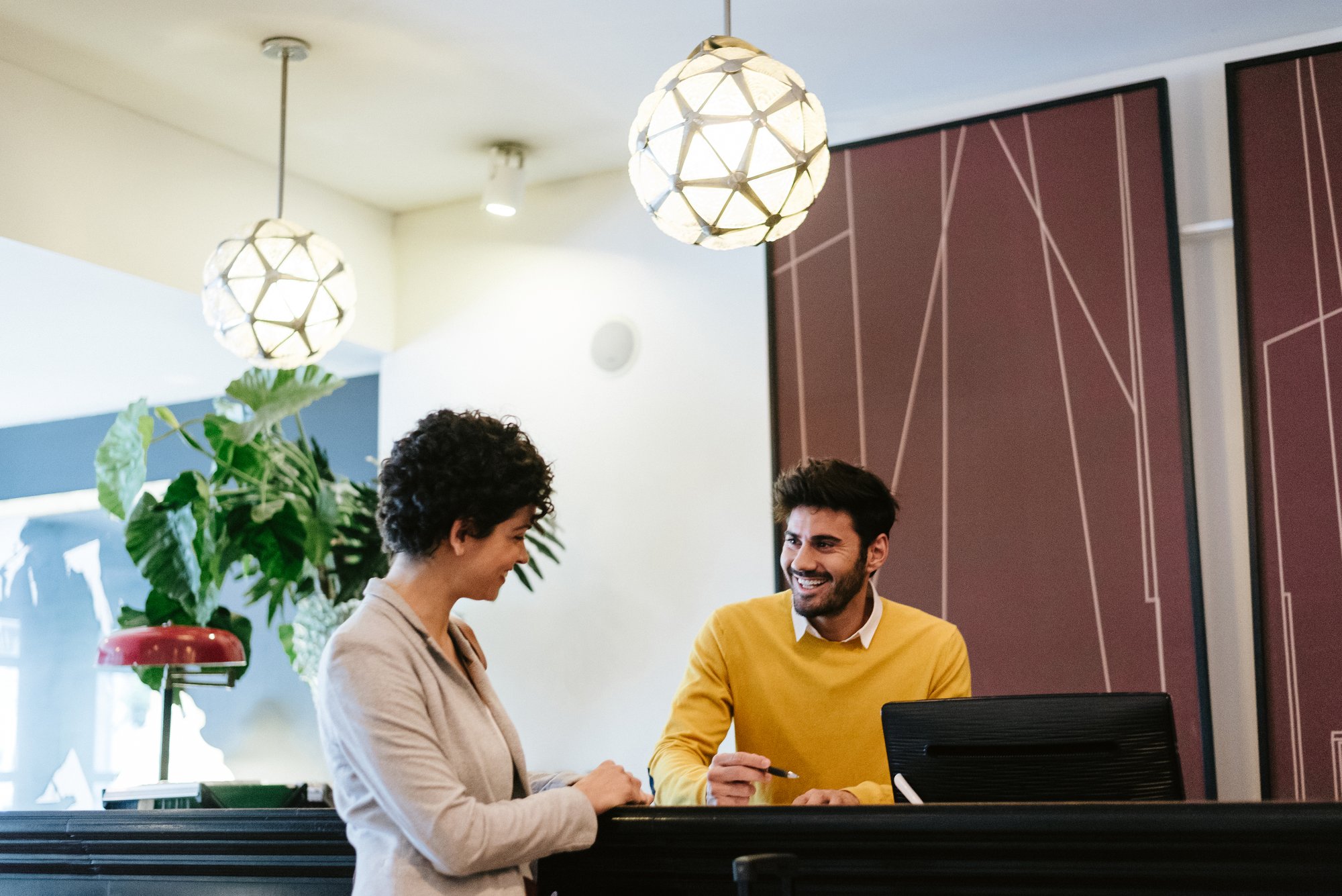 Hotel manager at desk helping customer